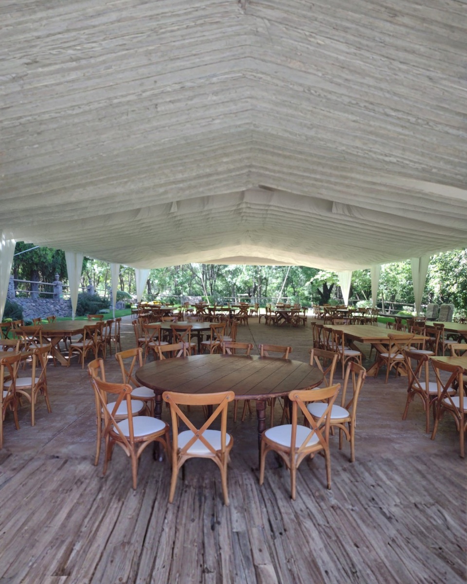 Carpa con mesas redondas de madera